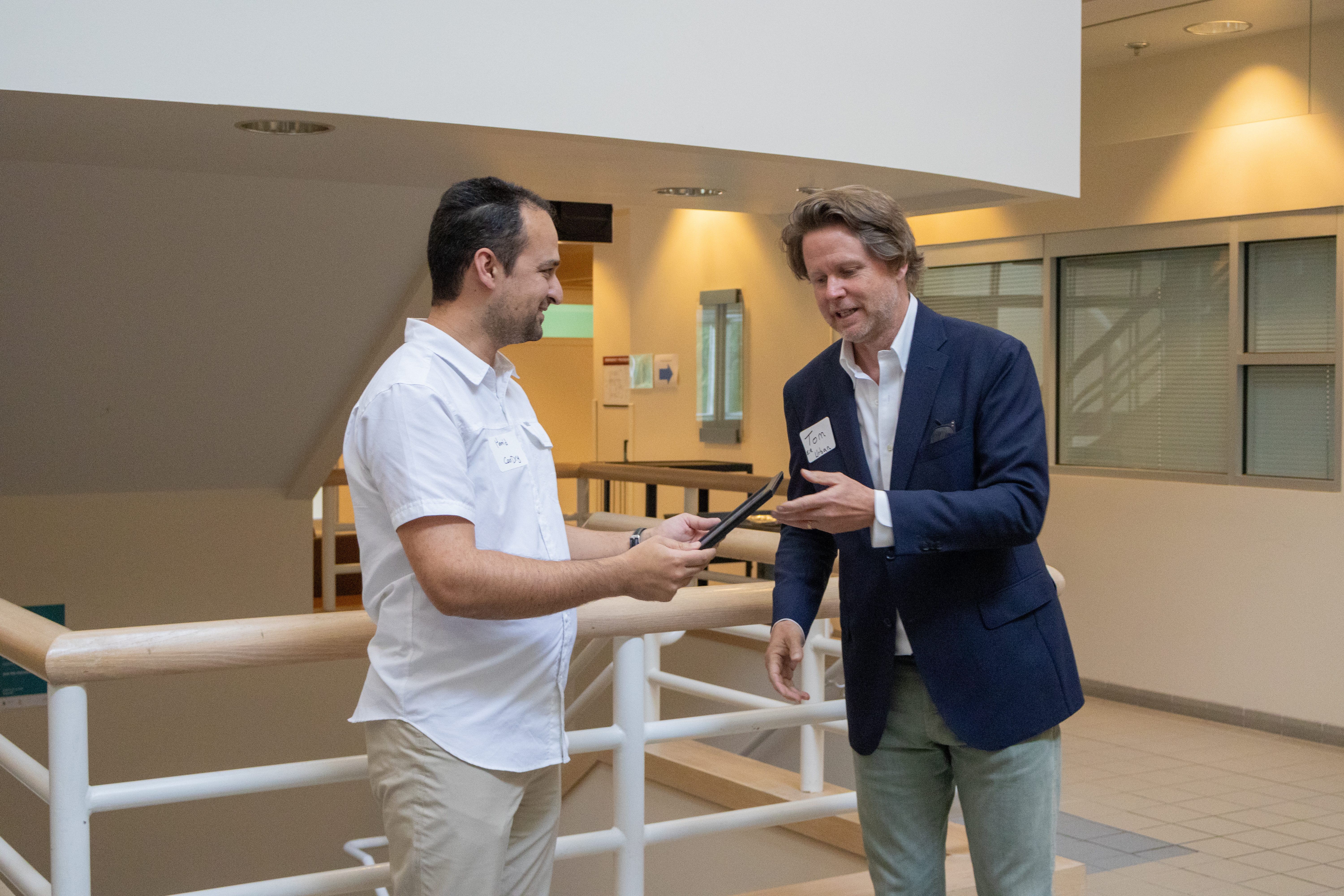 Two people smiling holding an award