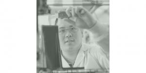 Man looking at a beaker in a lab