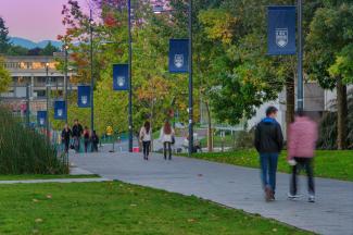 Students walking down street with UBC flags and green grass