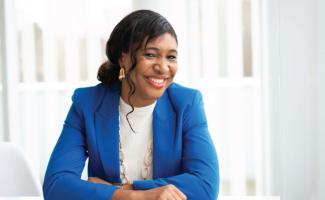 Pasima Sule: Dark skinned woman with black hair in a cobalt blue blazer and white shirt