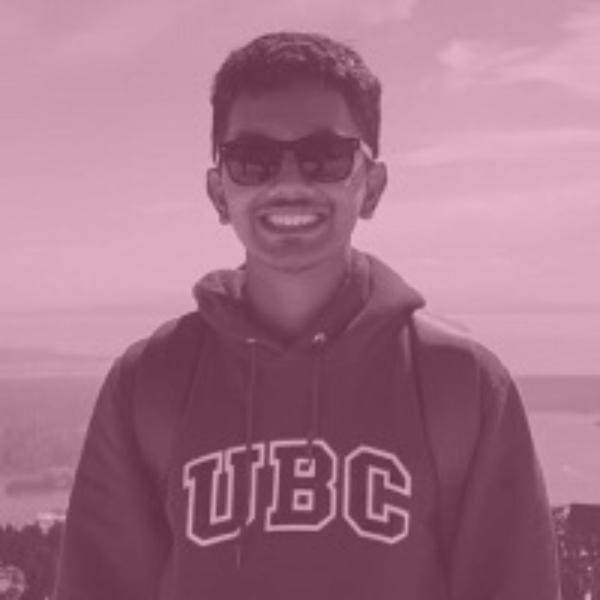 Man in a UBC sweatshirt and glasses smiling